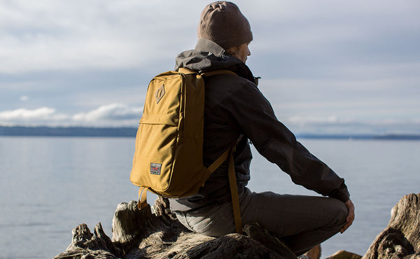 Person sitting and meditating or just spacing out on the beach while wearing the Guide's Edition Paragon.
